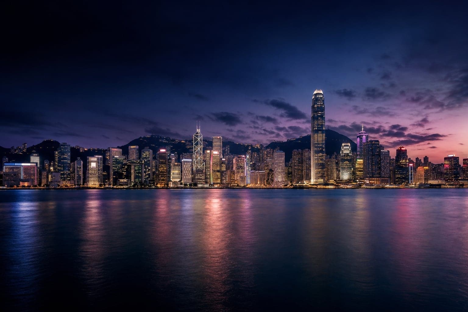 Hong Kong Island skyline at blue hour, viewed across Victoria Harbour